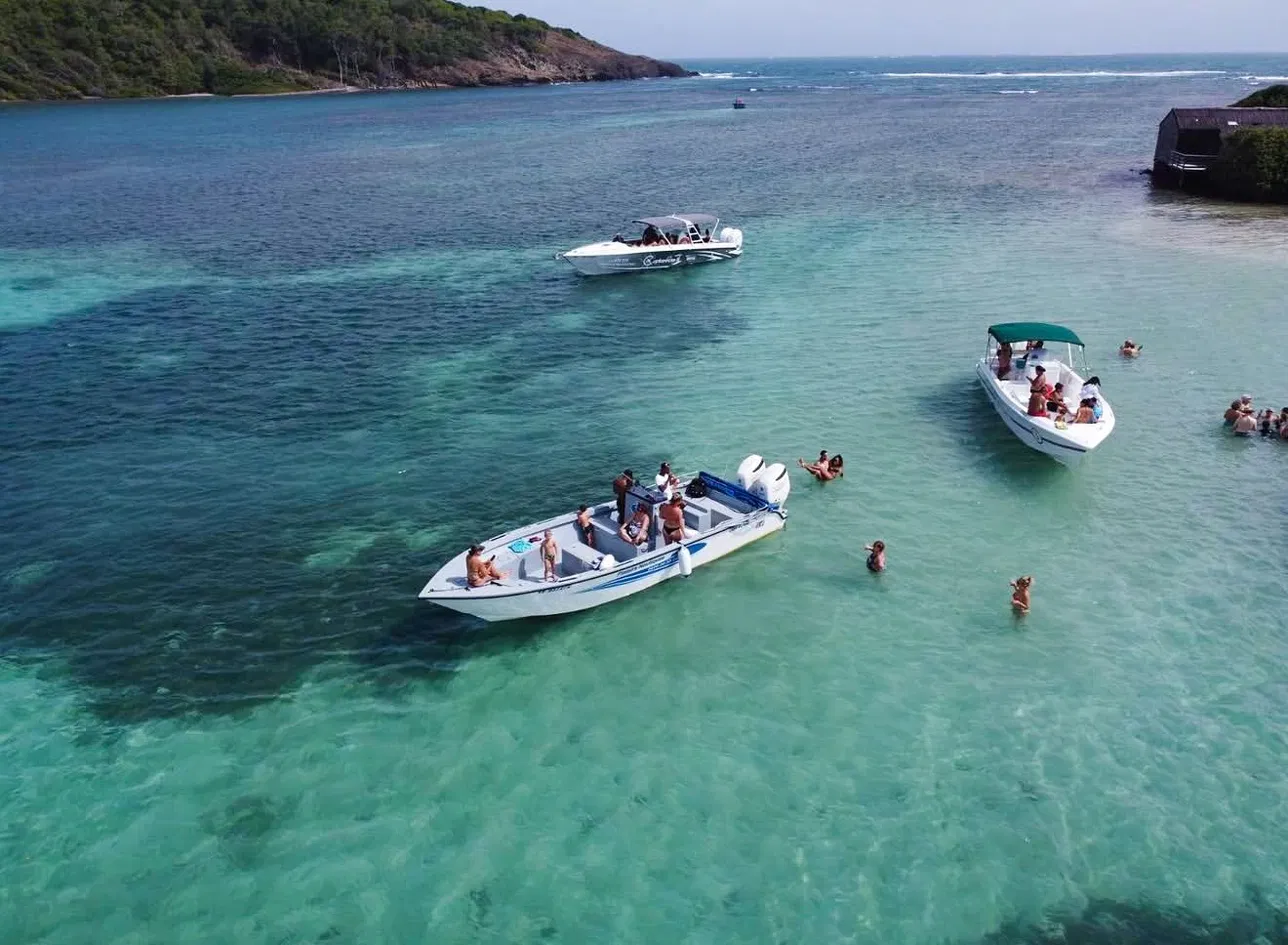 Vue drone de bateaux et baigneurs dans une eau turquoise en Martinique