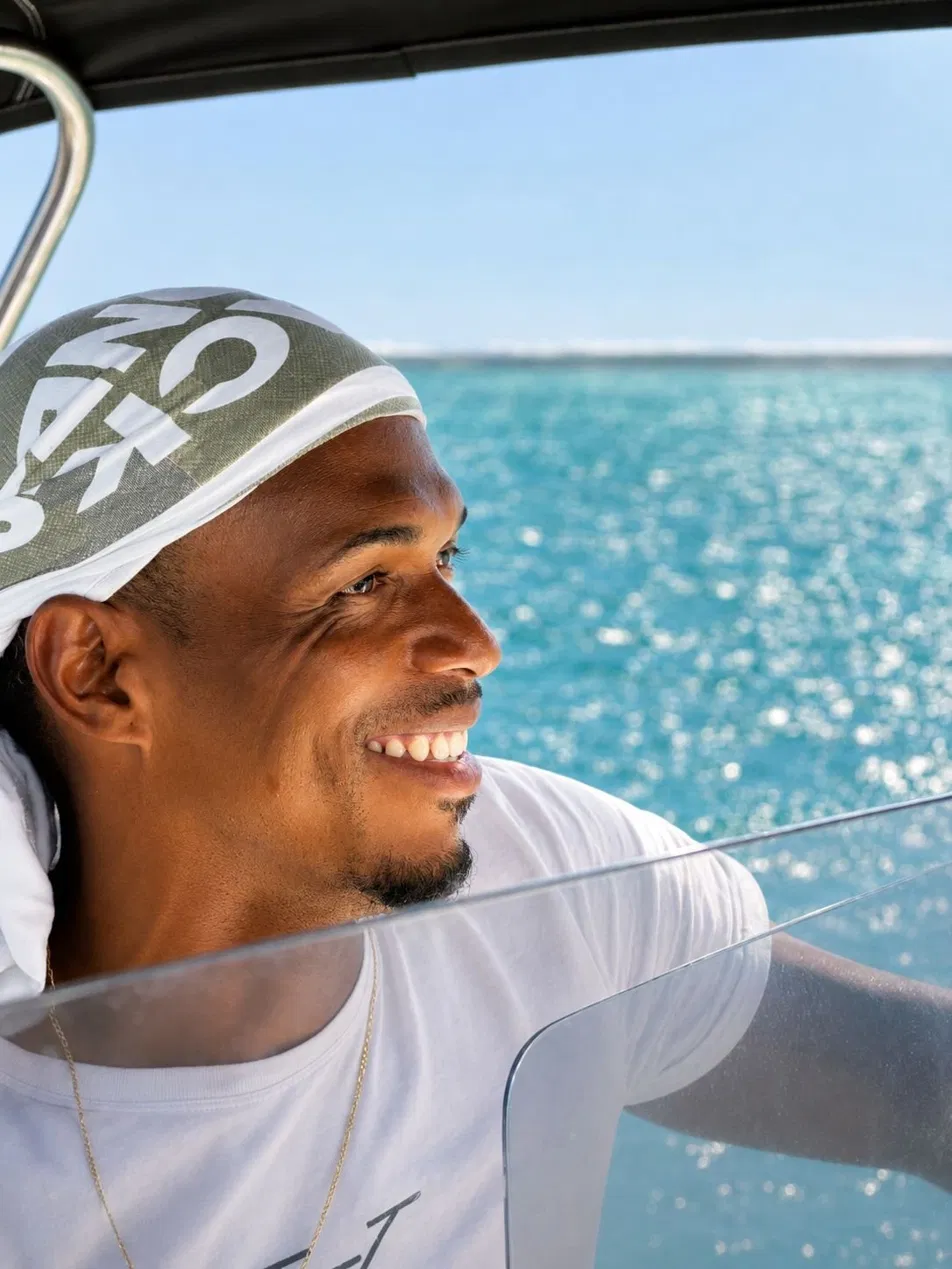 Portrait de Kenny souriant sur le bateau avec la mer en arrière-plan