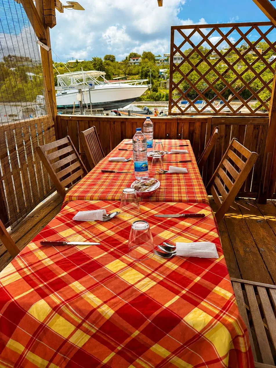 Table créole dressée avec vue sur le port et les bateaux