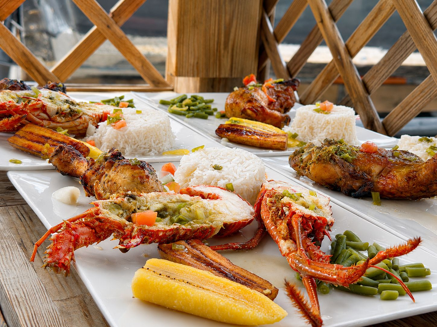 Assiettes créoles de langouste grillée, poulet boucané, riz et bananes plantain