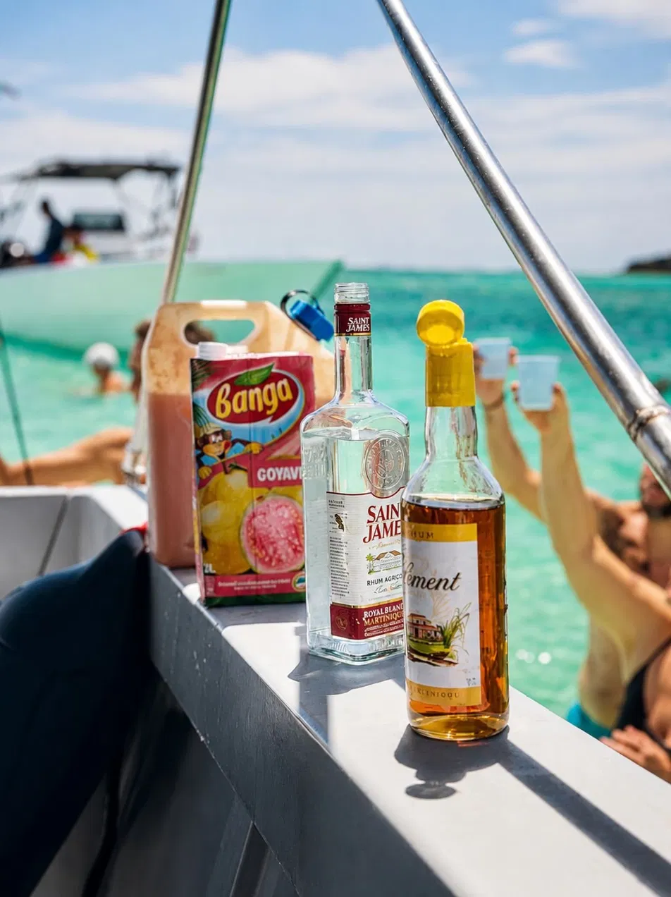 Ti-punch Saint James et Clément posés sur le bateau face au lagon